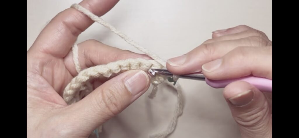 よね編みのコースターの2段目、一つ飛ばして細編みの目に針を入れる画像